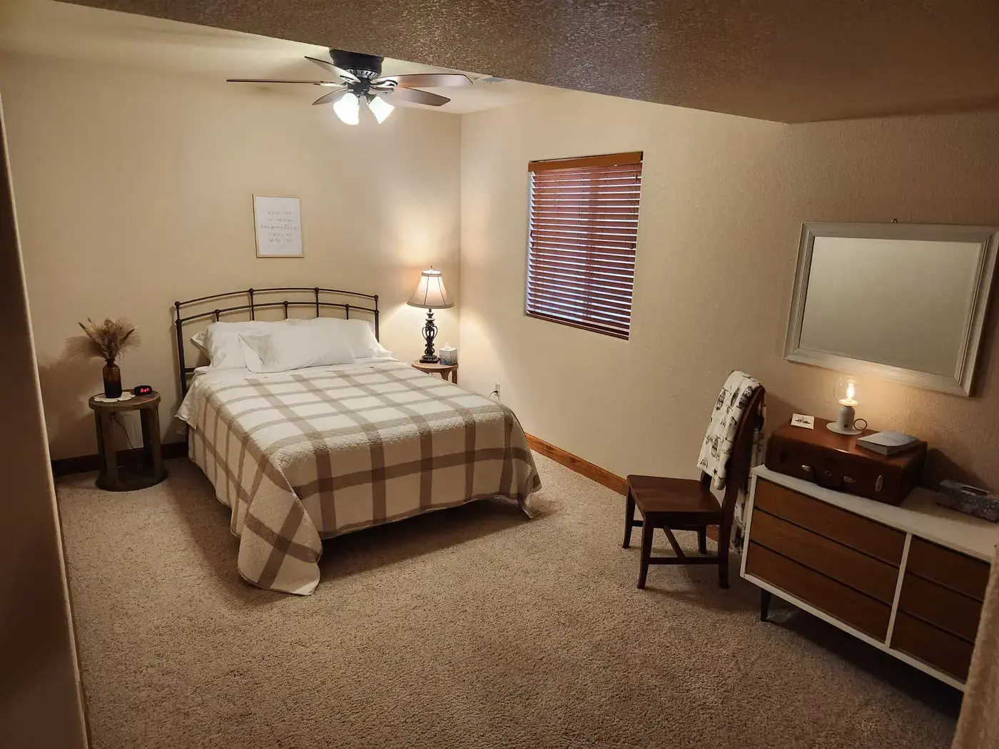 Denver Guest House bedroom with plaid bedding and warm lighting for comfortable overnight stays