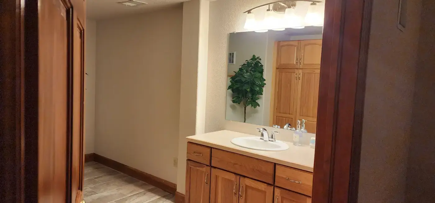 Denver Guest House clean bathroom with wood vanity for guest use