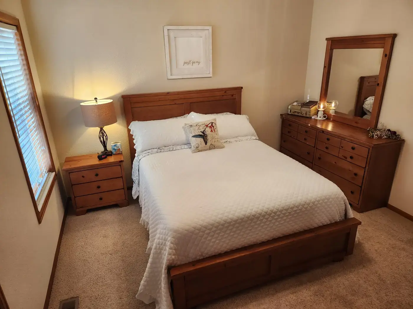 Denver Guest House bedroom with wooden furniture and white bedding for hospital family guests