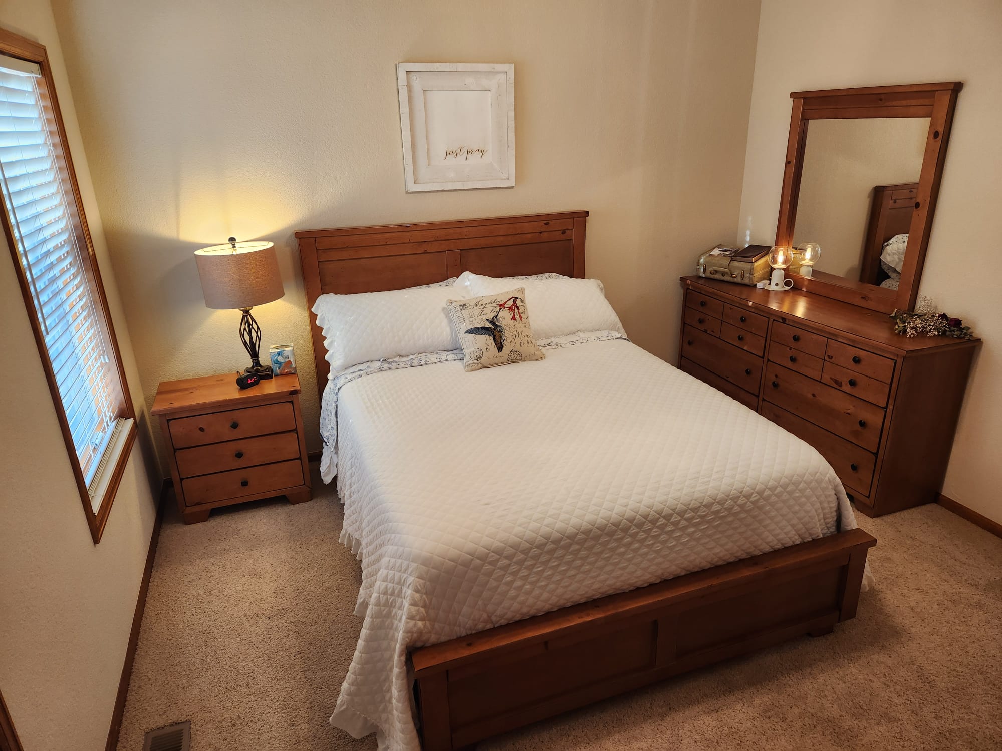 A cozy bedroom at Denver Guest Home with wooden furniture, white bedding, and soft lighting.